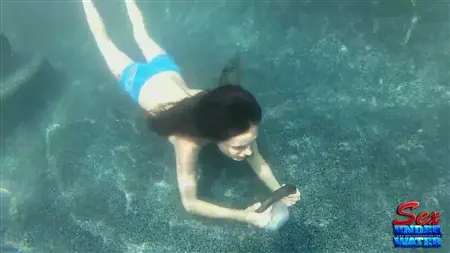 Flicka under vatten slickar en gummidildo