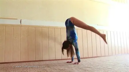 Flexibel skolflicka är engagerad i gymnastik på kameran