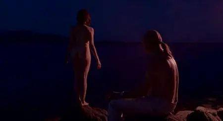Naked Girl står på natten vid sjön