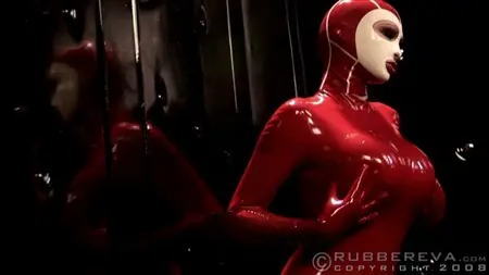 Spela tik i röd latex poserar sexuellt framför spegeln