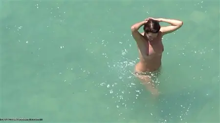 Killen bogging bakom de nakna paren som badar i havet