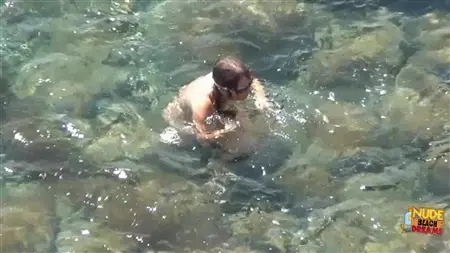 Killen spionerar på att han är en flickvän som badar i havet naken
