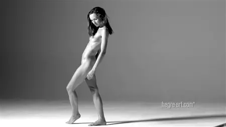 Attraktiv mager deltar i en naken fotografering