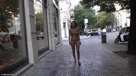 Promenad av en naken brunett i stadens centrum