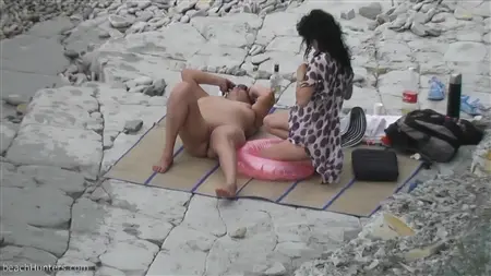 Slutty flickvänner med nakna tuttar slappna av på en öde strand