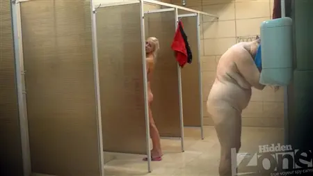 En smal blondin tvättas i en offentlig själ med feta kvinnor