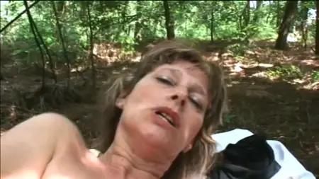 En mogen kvinna i skogen visar hennes charm och knulla med en man